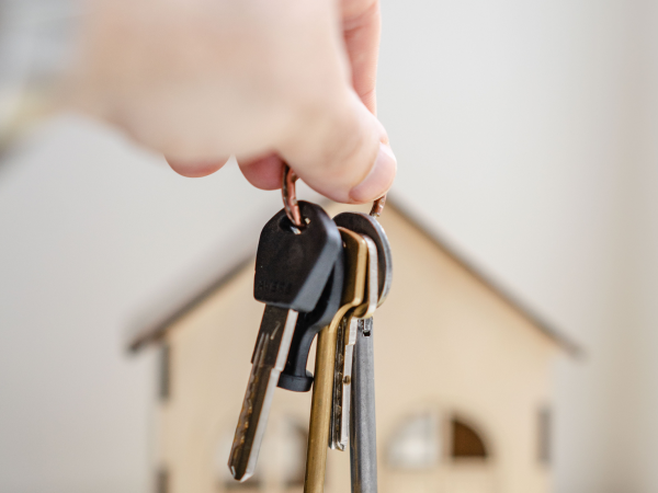 Buyer holding keys in front of model home