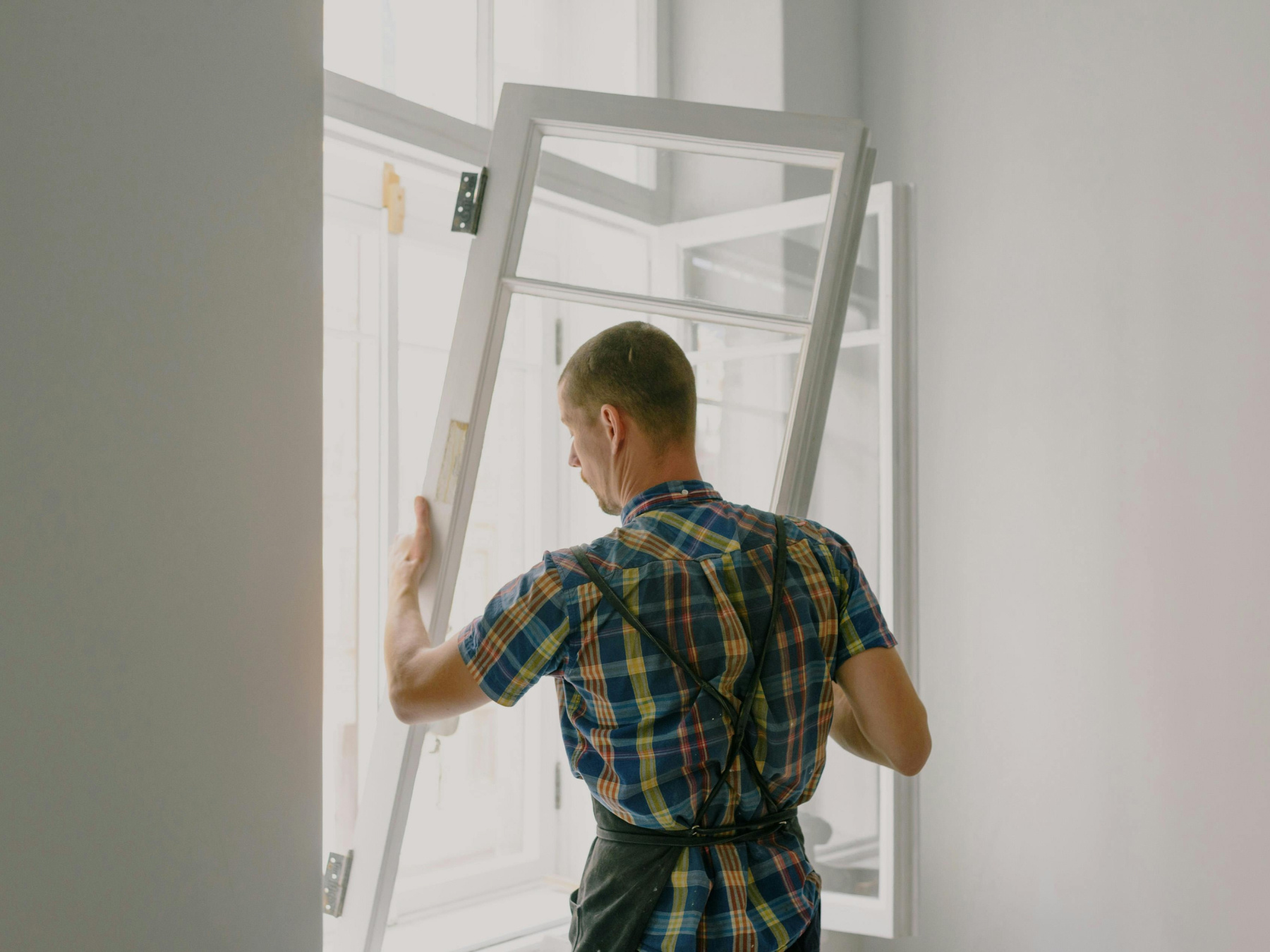 A man installs a new window frame