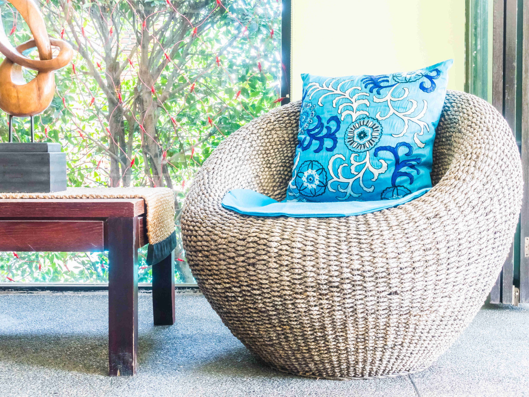 Woven material chair with a bright blue patterned cushion