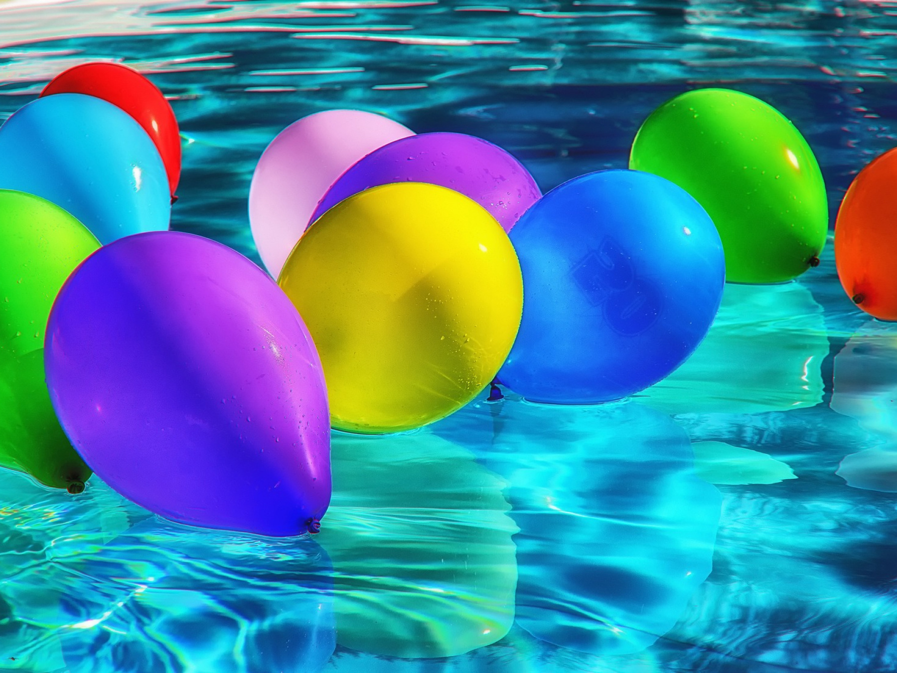 Colourful balloons floating in a pool