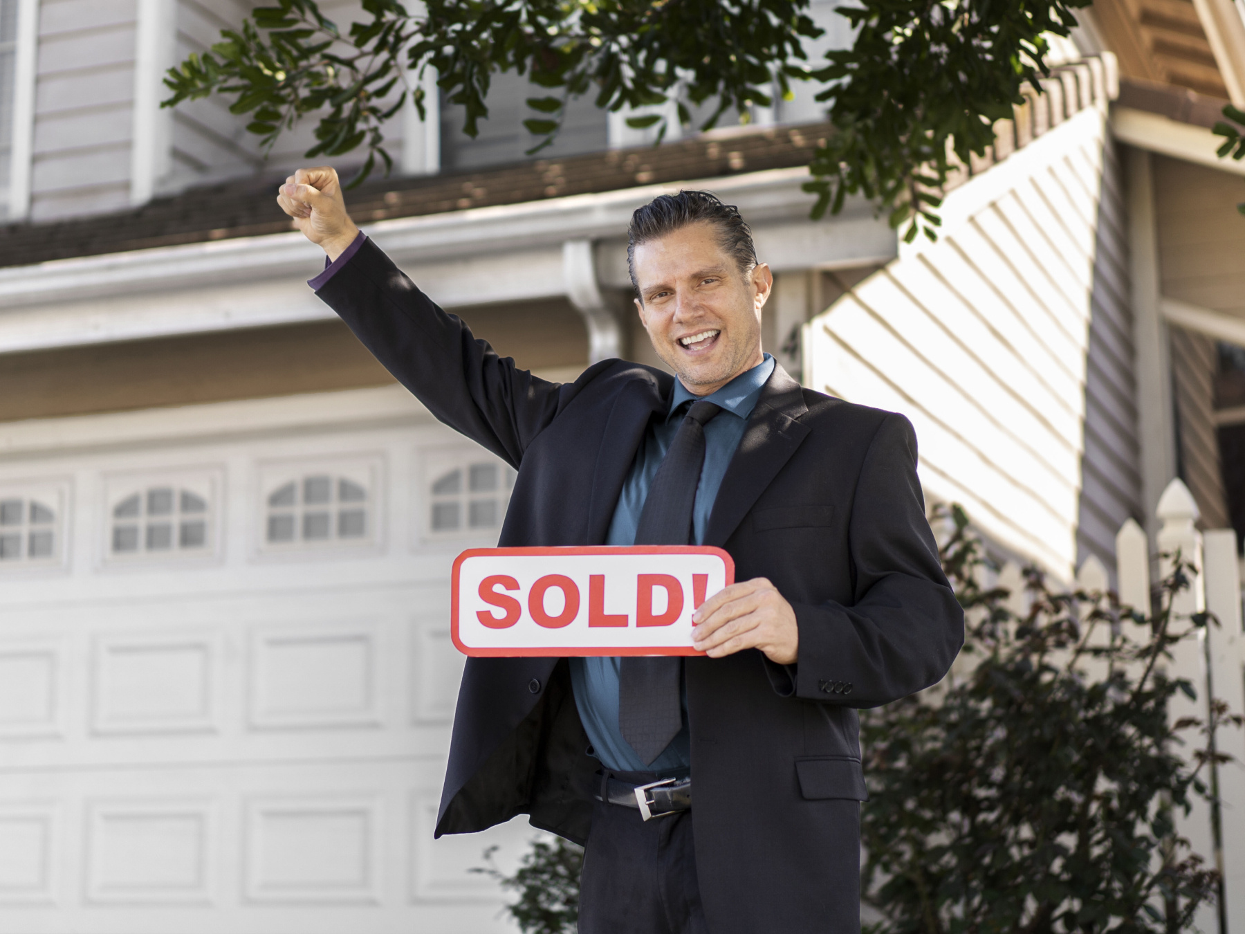 Property practitioner holding sold sign to represent home being sold at the right time