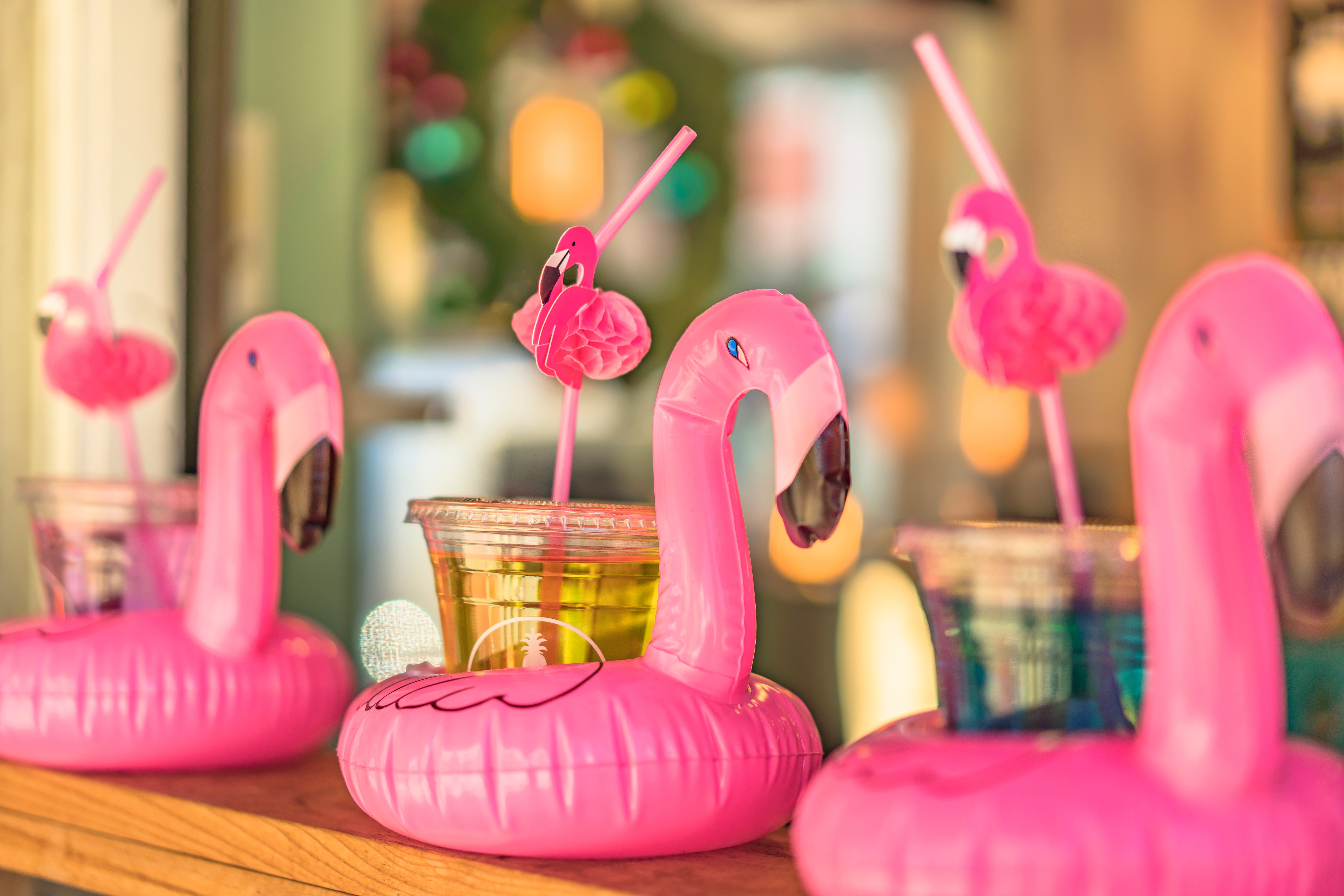 cocktail-glass-with-flamingo-shaped-straw-buoy-aligned-bar-counter