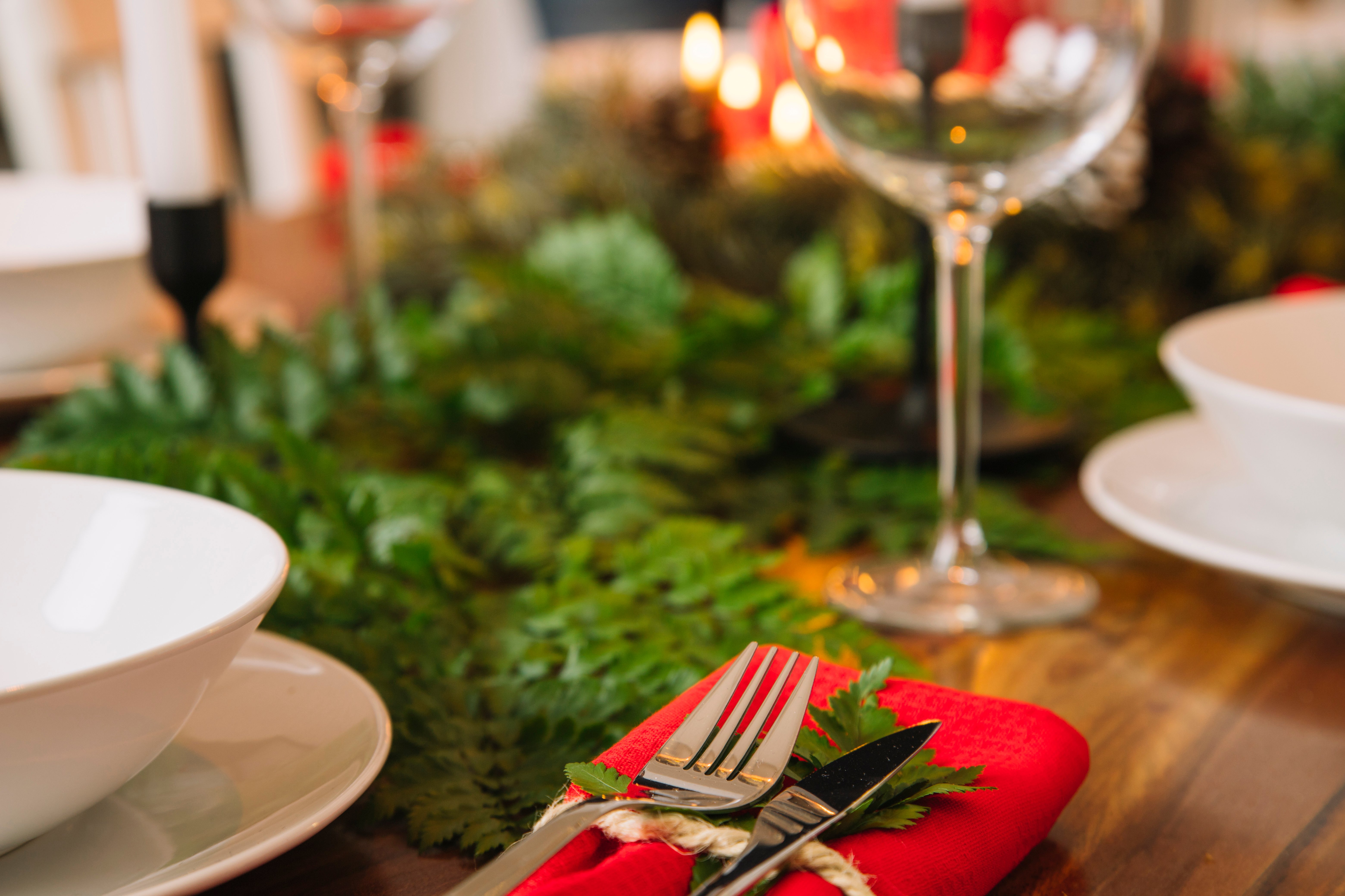 The combination of greenery and red napkins makes a festive table setting for Christmas