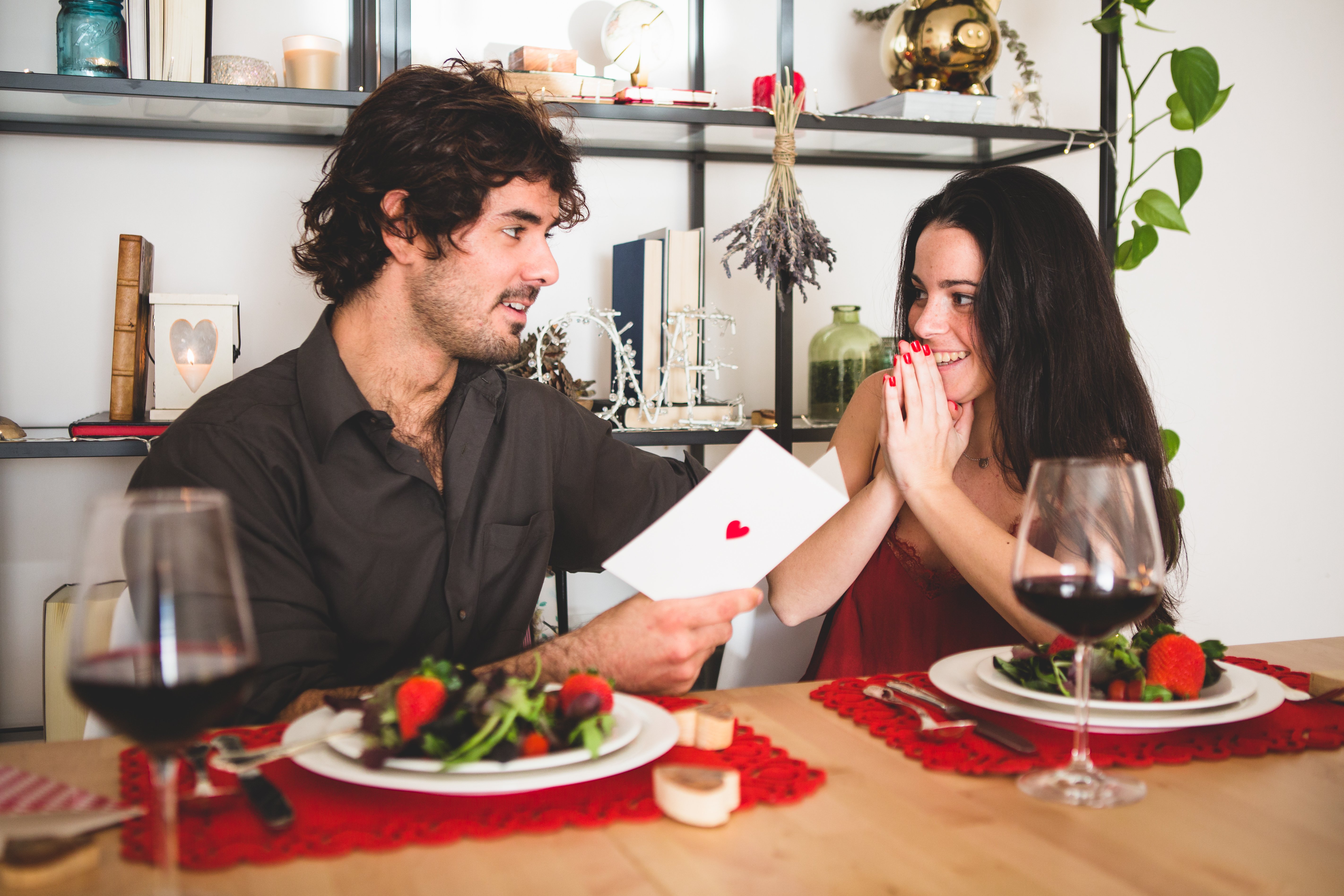 excited-girlfriend-while-her-boyfriend-reads-romantic-postcard