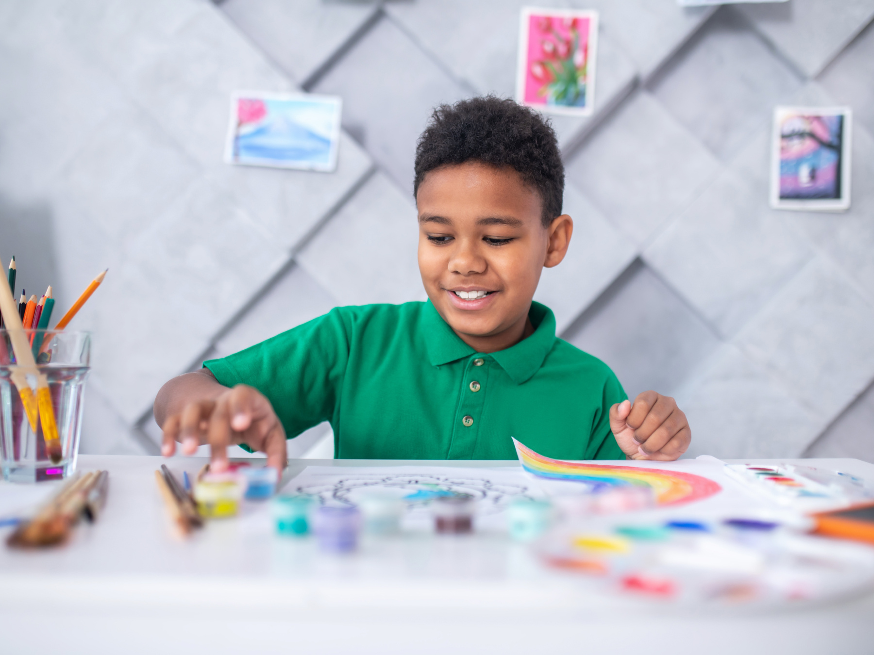 Small child with green t-shirt busy painting